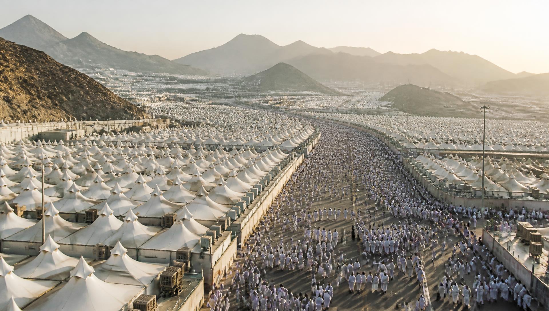 Aerial view of Hajj pilgrim tents in Mina with pilgrims walking towards Makkah